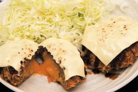 チーズの濃厚な味わいがご飯にピッタリ。紅生姜やカレー、梅じそなど11種類の変わり種メンチは店頭で1個から購入可能。一番人気は亀有メンチ(豚、1個170円)で一日に数百個売れることも