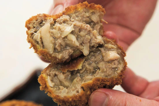 いまや吉祥寺の名物となった「元祖 丸メンチカツ」。これを求めて週末は100人以上並ぶときも。平日は20個まで、土・日・祝日は10個までの個数制限もある。雨の平日は比較的空いている