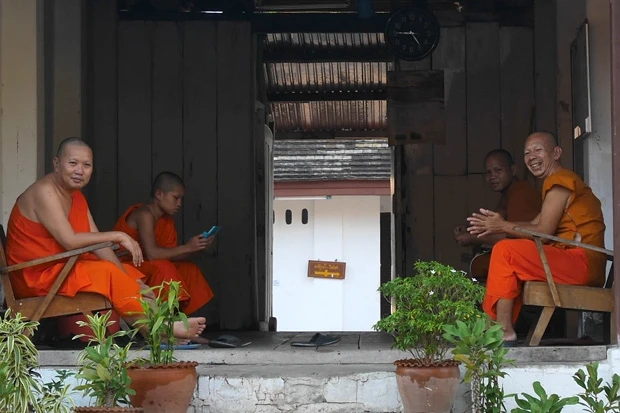 寺院内の僧たち。最近の若い僧は手元にスマホ