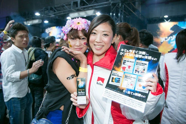 『マールボロ フュージョン ブラスト』のサンプリングを配るお姉さまと、フェスでテンション上がったステキ女子。