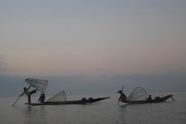 フレーと呼ばれる小型の船に乗った漁師。片足で立ち、もう片方の足で櫂(かい)を操るインダー族の伝統的な漕ぎ方