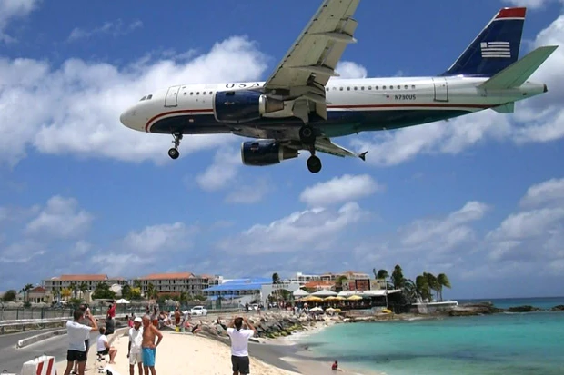 左端のフェンスから空港。右はビーチ。この飛行機、さらにもう一段低く下がります。