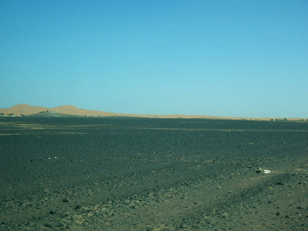 こんな砂利道を走ってきて、やっと砂漠が見えてきた