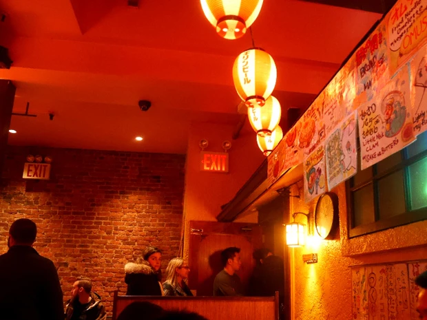 和風居酒屋。壁のメニューには「あさりバターさかむし」の文字も