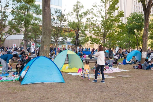 飲食エリアではシートやテントを広げ、餃子を食べながらくつろぐ人々が