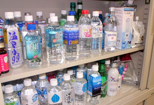 研究室には藤田先生が「毛髪によい」と言うシリカ入りの水がずらりと並ぶ(上段)。上段左から2本目の「FIJI」は少しおしゃれな雑貨屋などでよく見かける商品だ