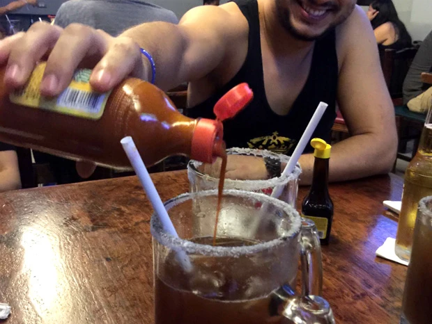  うれしそうにミチェラーダにサルサソースを足す友人