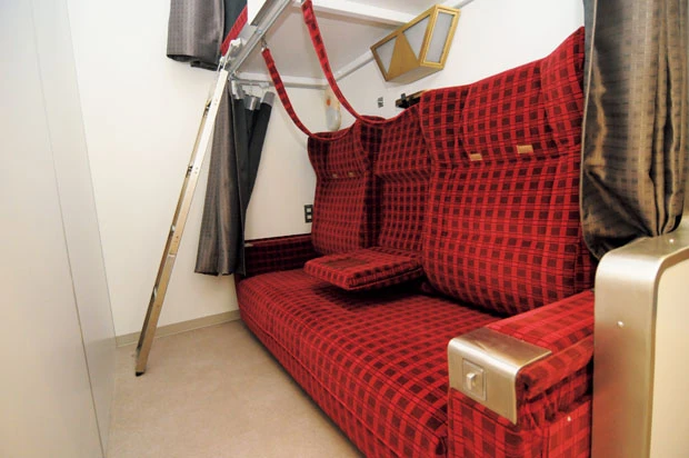 さまざまなタイプの寝台が。北斗星の「A寝台ツインデラックス」を使ったドミトリーも用意。こちらは椅子を倒すとベッドになる。照明や読書灯も実際に北斗星で使われていたもの。AC電源は2口用意