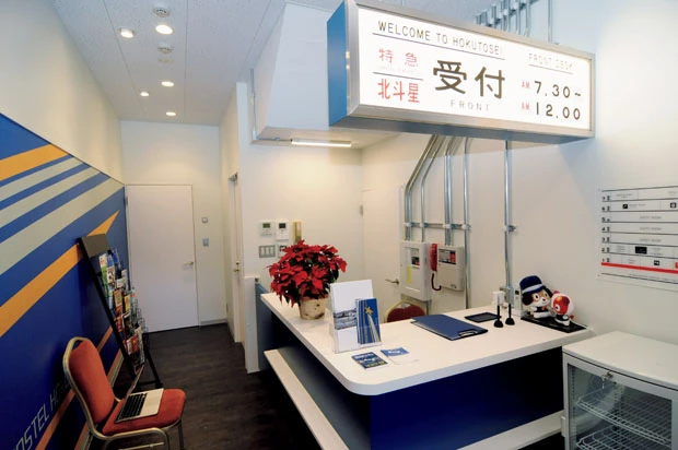 受付の壁には北斗星の機関車に描かれていた流れ星のマーク。フロントの案内板は方向幕をかたどったデザイン