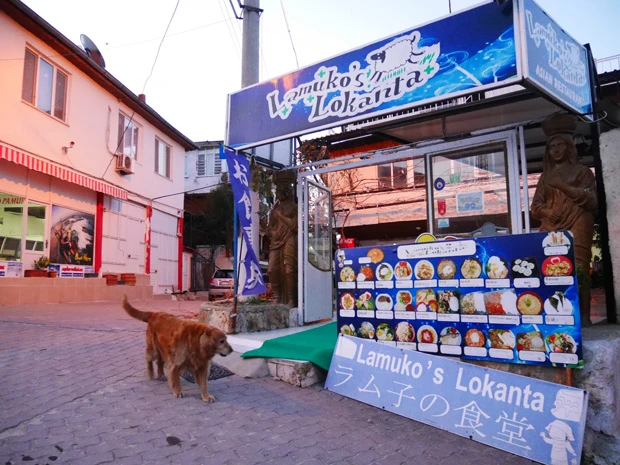「ラム子の食堂」外観と、お店の看板犬ケント君。リードを付けずに自由にお散歩する彼はこの街の人気者