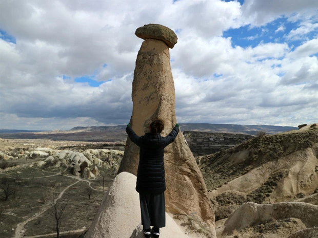 定番のトリックアート写真、しめじ型の奇岩にハグ!