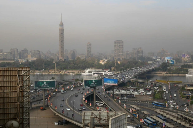汚染された空気で霞むビルの足元を流れるナイル川