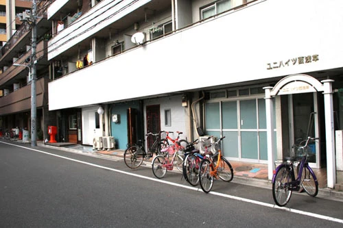  「新吉原」の販売店「岡野弥生商店」が構える西浅草は浅草と吉原の間に位置し、住宅街となっている。店舗はこの建物の白い扉