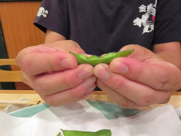 正しいえだまめの持ち方。「食べづらい豆は皮ごと噛みちぎるので、口の中に皮がたまる」