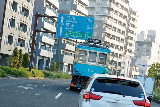 早朝５時、東京と横浜を結ぶ幹線道路を東京方面に北上。道路を走る姿を見て、自家用車のドライバーや、新聞配達員、朝の散歩をする人たちがスマホを向けて、青い電車を撮影していた
