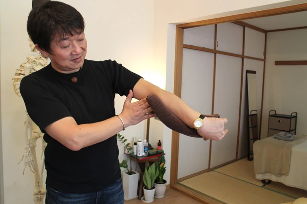 写真のようにねじれていれば必然的に流れが悪くなり、硬くなり、不調が起きる…長坂院長がタオルを使い発想の原点を説明する