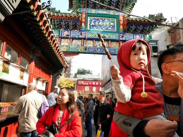 イモ虫の串を持った子供