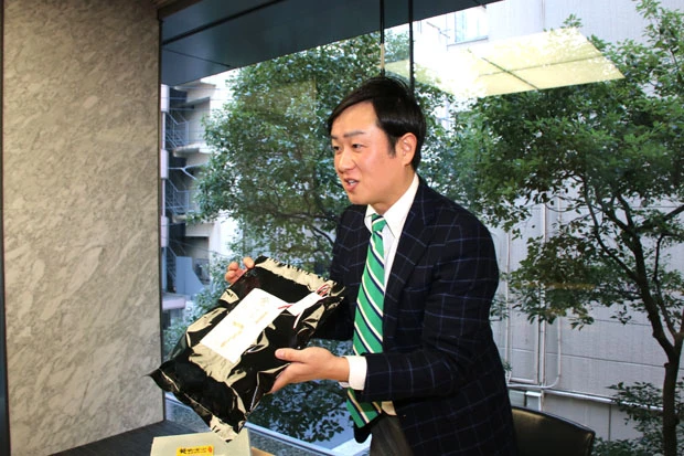 贈答用の柿ピーについて熱弁する中倉氏。「こんな高級感あれば、柿ピーだと思わないでしょ。お土産にピッタリなんですよ!」