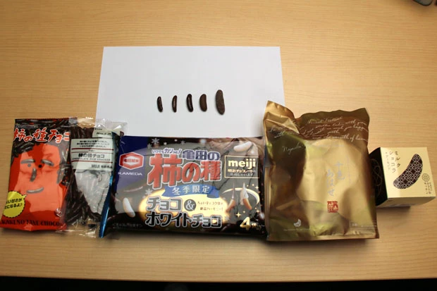 チョコレート系の柿の種を並べるとその大きさや形の違いが一目瞭然。さらにチョコのコーティング具合まで違って、柿の種の形を活かした凸凹のものや、よりスイーツ感を出すためにぶ厚く塗ったものまで千差万別だ