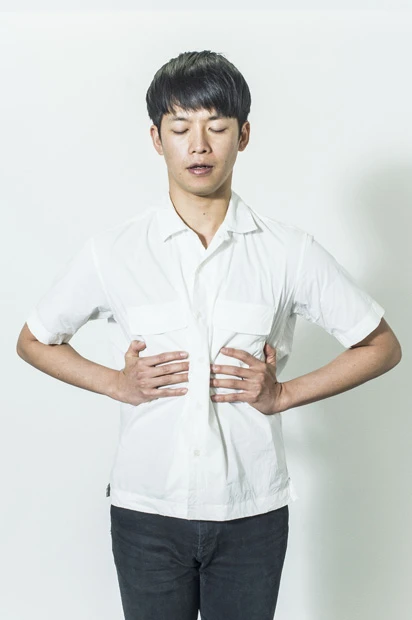 【1】両手を肋骨にあて、肋骨が中央に寄って狭まるのを確認しながら頭から息を吐くイメージ