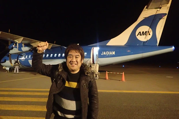 連続搭乗を終えガッツポーズを見せる記者。笑顔がぎこちないのは撮影を頼んだ空港スタッフがタイプだったから