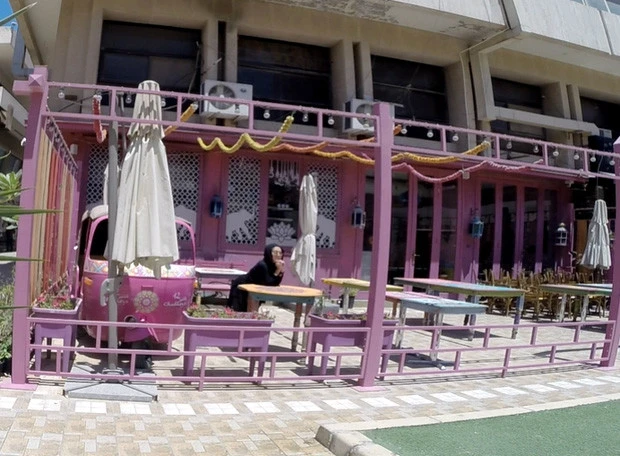 ピンクのカフェでぶりっこポーズのムスリムガール