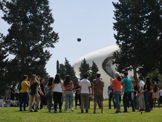 中庭でバレーボールをする若者たち