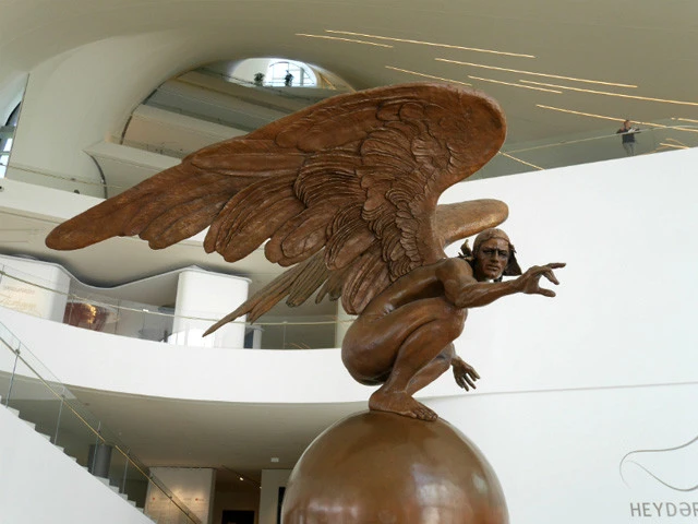 困惑顔のブロンズ像。その奥の天井方向を見つめると、ノートを丸めて望遠鏡にしたような空間が伺える