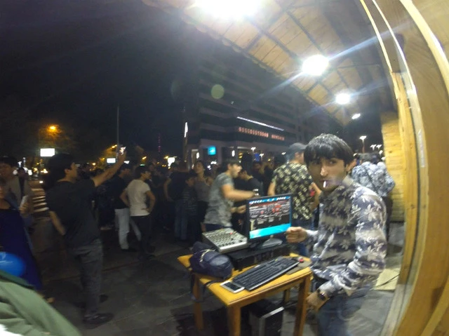 路上で踊る人々とDJ