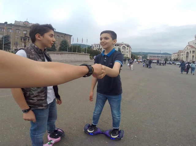 子供に手を引かれて、体重移動で動く電動ボードに乗っているところ。怖くて手が離せない......