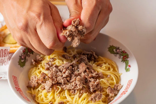 (1)ちぎる! ラ王の麺を鍋でゆでたら湯切りして丼に移し、マクドナルドのハンバーガーの肉だけを細かくちぎって入れる。ハンバーガーはできればケチャップとマスタード抜きで注文しよう