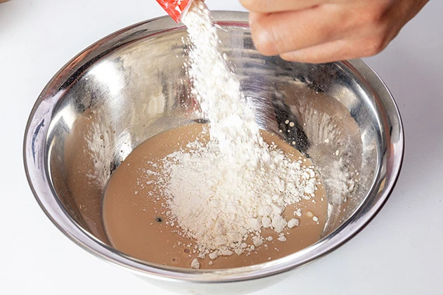 (1)小麦粉! 砂糖多めで注文したタピオカミルクティーをそのままボウルに移し、そこに小麦粉を投入する。かき混ぜながら小麦粉の分量を調整し、全体がネットリしてくればOK