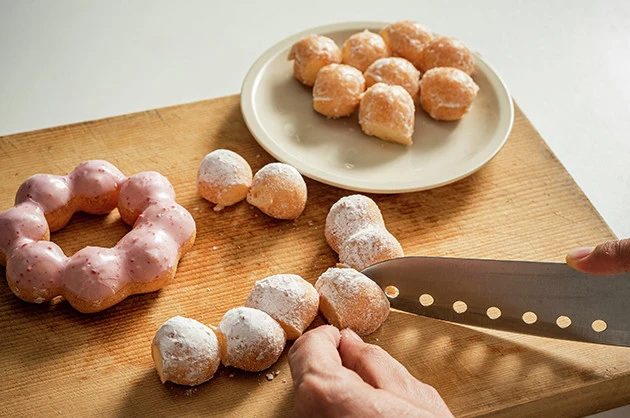 (1)解体! 小さな玉がつながったような形状のポン・デ・リングを包丁で切断し、8つの玉に分解する。自由自在なカスタムをするために解体は不可欠。細かくすれば一気に自由度がアップ!