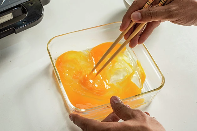 (1)たまご! 平皿またはボウルに卵を割り入れて溶き、食パンにたっぷりと吸収させる。お好みで砂糖や牛乳を入れてもいいが、今回はハーゲンダッツの甘さを生かすため卵だけにした