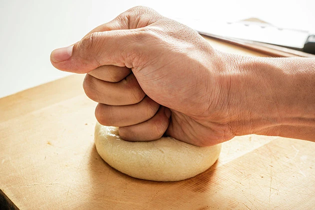(2)潰す! 肉まんをグーで軽く潰し、形を平べったい状態に整える。強く押しすぎると中身が飛び出てしまうので要注意。また、買ってすぐの状態だと熱いのでやけどにも気をつけよう