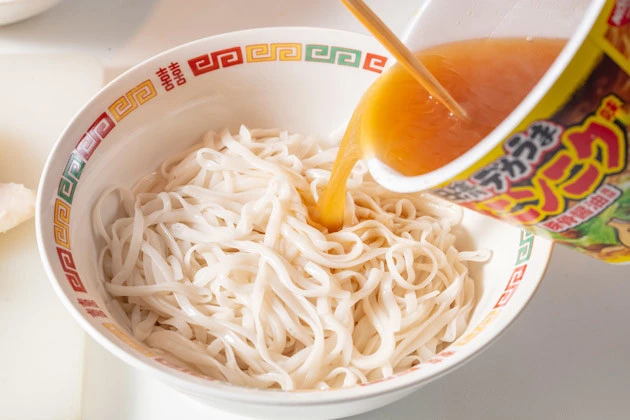 (3)スープ投入! 「日清デカうま 豚ニンニク味」の粉末スープを熱湯で溶かし、温めた糖質0g麺の上から注ぐ。二郎の味に近いのに50kacl未満という奇跡のスープを使わない手はない!
