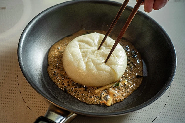 (3)焼く! 熱したフライパンに油そばのタレを入れ、潰した肉まんの両面を中火で焼く。タレを生地に吸収させるように動かしながら焼き、こんがりと焦げ目がついたら完成