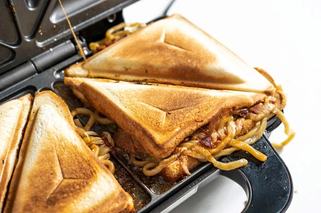 (3)完成! 5分ほどしたらホットサンドメーカーのフタを開け、中心から半分にカットすれば完成。無理やりフタの中に押し込んだのに、見事にホットサンドとして焼き上がるのはすごい!