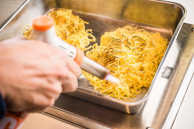 (3)バーニング! 湯切りした麺をガスバーナーで豪快に炙り、表面に焦げ目をつける。麺を焼くという背徳感がたまらない。オラオラオラ、麺よ燃えろ燃えろー!! アヒャヒャヒャヒャーッ!!