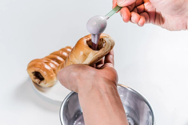 (4)入れる! 空洞になったコロネに錬成した「ねるねるねるね」を入れて完成。30年以上にわたって練って舐める以外に食べ方が存在しなかったのが不思議なくらい、パンとの相性が、イイ!