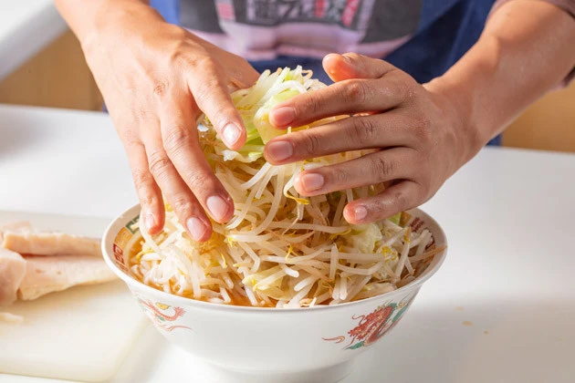 (4)盛る! あとは野菜と刻みニンニク、サラダチキンを盛り付け、チョモランマのように立派な山を作ろう。野菜はどんなに盛っても低カロリー。思う存分マシマシすべし!