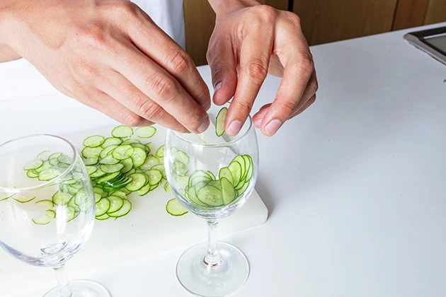 (2)擦りつけ! スライスしたキュウリをグラスの内側から擦りつけながら貼りつけよう。キュウリの汁が搾り出されるくらい強く押そう。グラスはあらかじめ冷やしておくとなおよし