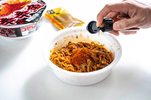 （３）追い辛味！　さらにシビ辛カップ麺の限界を目指すため、花椒パウダーとラー油もガッツリ投入。この時点で目にも鼻にも刺激がヤバい！　それでも行こうぜ、ピリオドの向こうへ！