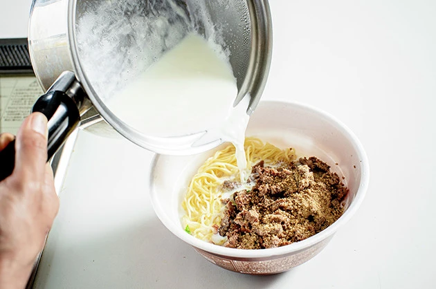 (4)盛りつけ! 湯切りをした麺にスープとすりごまを入れ、熱した牛乳で溶かした後、刻んだマックを盛りつけたら完成。辛くしたい場合はラー油や花椒などを追加して味を整えよう