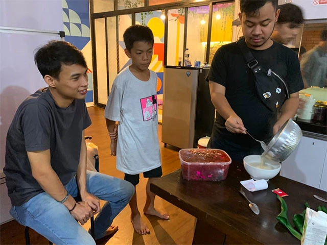 少年と宿スタッフのお菓子作りを見る