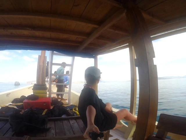 船のクルーを見つめながらコーヒーをすする