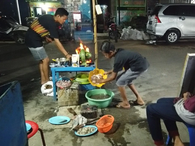 地面で魚を切ったり洗ったりしてる