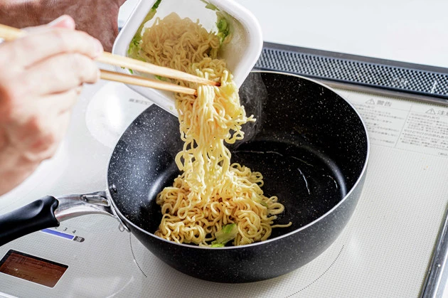 (1)焼く! 焼そばモッチッチに熱湯を注ぎ、湯切りをしたら軽く油を引いて熱したフライパンで麺を焼く。すでに麺に火は通っているので、中火~強火で軽く焦がすように焼くのがポイント