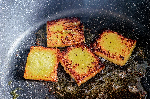 （３）焦げ目！　熱したフライパンにガーリックマーガリンを吸収させたパンを入れ、両面を軽く焼いて焦げ目をつける。表面を焦がすことでガーリックをパンの内部に封じ込めることができる