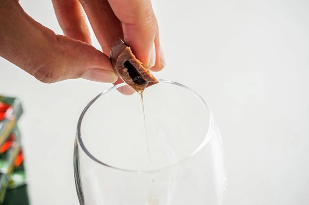 （２）入れる！　バッカスの中身が見える状態になったらグラスなどに垂らして集めよう。どうしてもチョコの破片も入ってしまうがこの時点では気にしなくて大丈夫。手際よく作業を進めよう